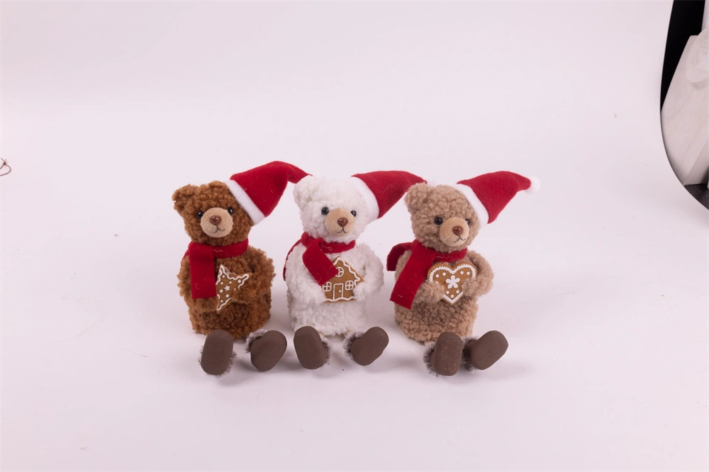 IRIS textil medve ülő, mikulás sapkában, mézeskalács süteménnyel a kézben,   18 cm